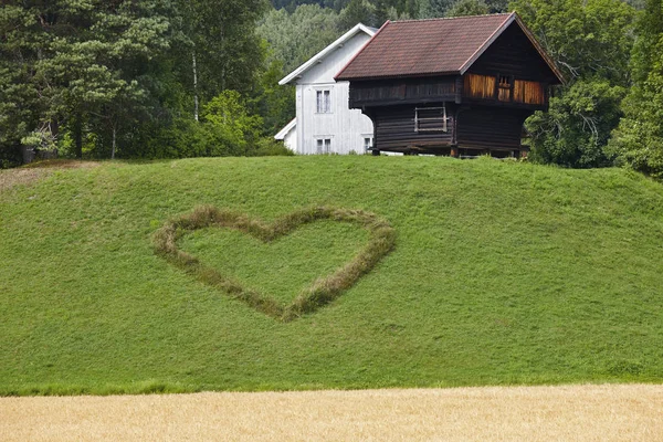 国のノルウェーの伝統的な農家の家と心のシンボル — ストック写真