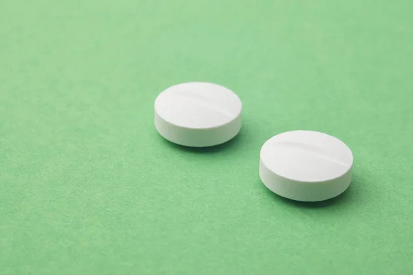 Pillole su sfondo verde. Trattamento farmacologico. Assistenza sanitaria — Foto Stock