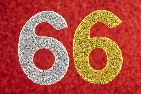Номер шестьдесят шесть серебристо-желтый цвет на красном фоне . — стоковое фото