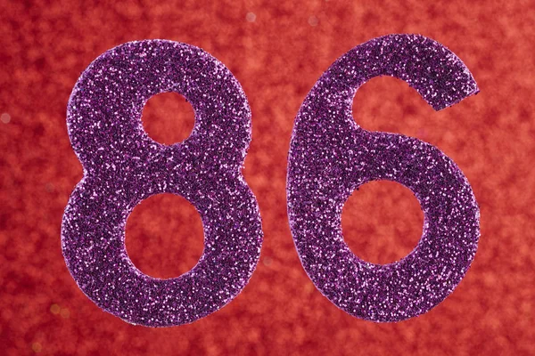 Número 86 cor roxa sobre um fundo vermelho. Anniversar — Fotografia de Stock