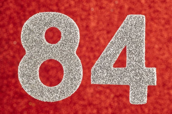 Numer osiemdziesiąt cztery srebrny na czerwonym tle. Anniversa — Zdjęcie stockowe
