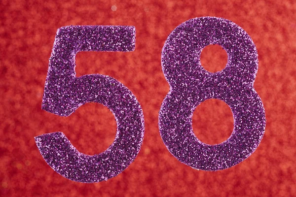 Número cincuenta y ocho color púrpura sobre un fondo rojo. Anniversa —  Fotos de Stock