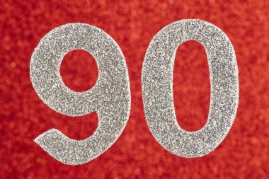 Doksan gümüş rengi kırmızı bir arka plan üzerinde numara. Yıldönümü. 