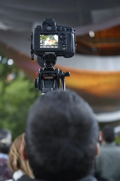 Mladý muž fotografování se stativem. Venku — Stock fotografie