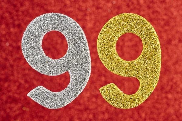 Numer srebrny kolor żółty dziewięćdziesięciu dziewięciu na czerwonym tle. An — Zdjęcie stockowe