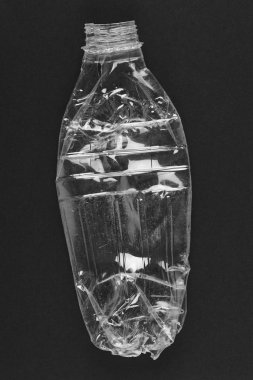 Siyah arka plan ile ezilmiş plastik şişe. Geri dönüşümlü çöp