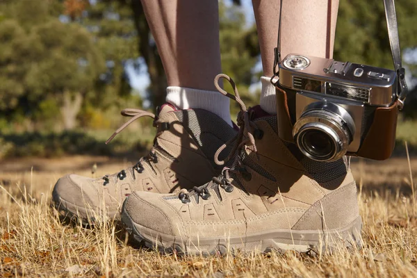 Oldtimer-Kamera mit Wanderschuhen auf dem Boden. Reise — Stockfoto