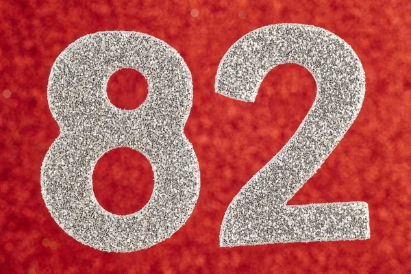 Number eighty-two silver color over a red background. Anniversar