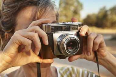 Kadın vintage fotoğraf makinesi ile fotoğraf çekmek. Seyahat 