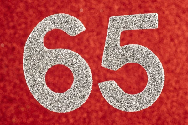 Número sessenta e cinco cor de prata sobre um fundo vermelho. Anniversar — Fotografia de Stock