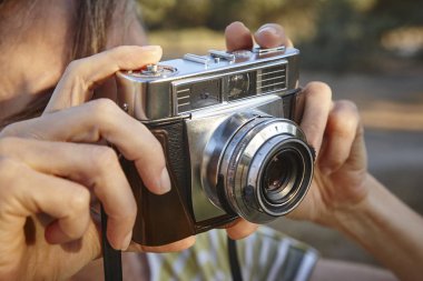 Kadın vintage fotoğraf makinesi ile fotoğraf çekmek. Arka plan seyahat. 