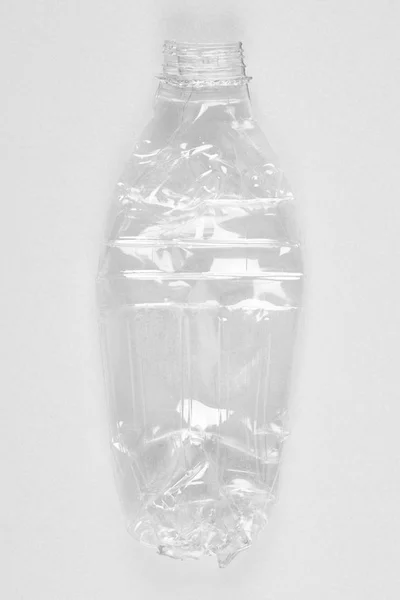 Rozdrcené plastová láhev s bílým pozadím. Recyklace odpadu. — Stock fotografie