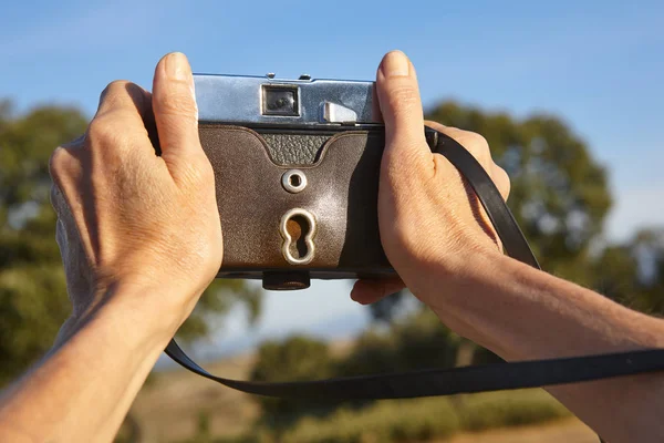Hands on vintage camera in the countryside. Travel background. — Stock Photo, Image