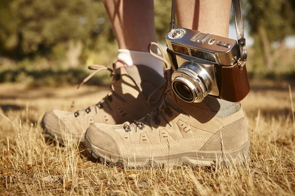 与在地面上远足靴的老式相机。旅行 — 图库照片