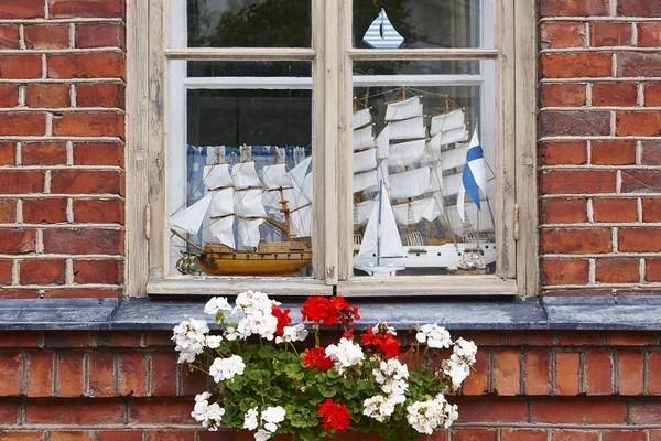 Oude bakstenen gevel met houten venster en model jachten. — Stockfoto