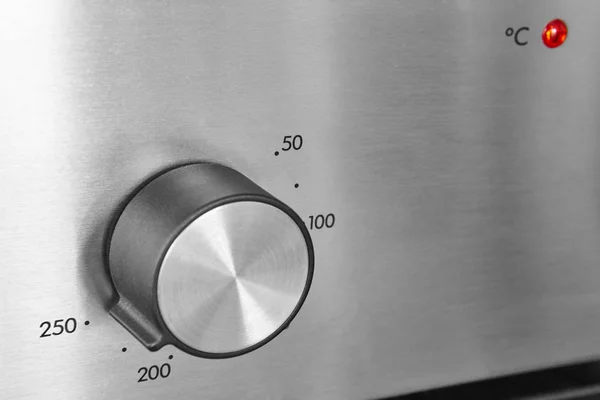 Oven knob detail over a metallic surface. Kitchen equipment. — Stock Photo, Image