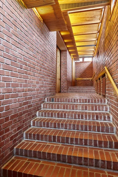 Paredes de ladrillo rojo y escalera con techo de madera pasillo interior — Foto de Stock