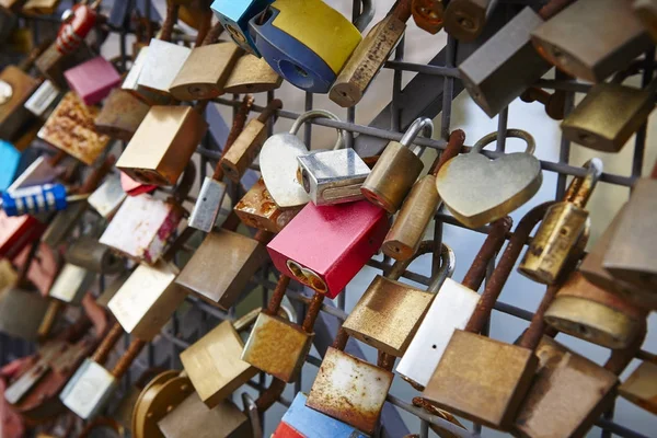 Colored rusted padlocks chained on a bridge handrail. Romantic — Stock Photo, Image