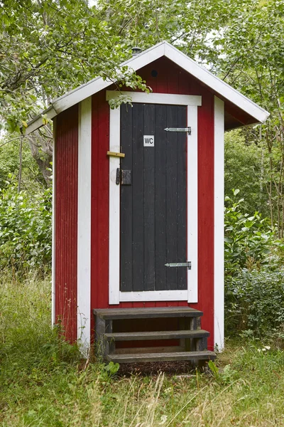 Ormanın içinde WC kırmızı ahşap kabin. Kırsal lavabo — Stok fotoğraf