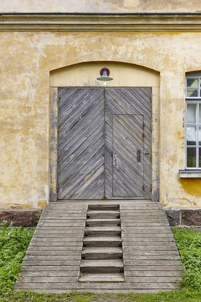 Façade d'usine antique avec portes et rampe en bois — Photo