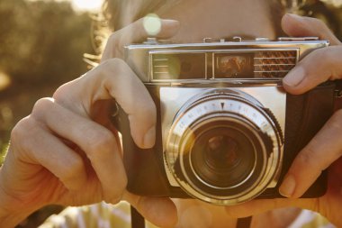 Kadın vintage fotoğraf makinesi ile fotoğraf çekmek. Arka plan seyahat.  