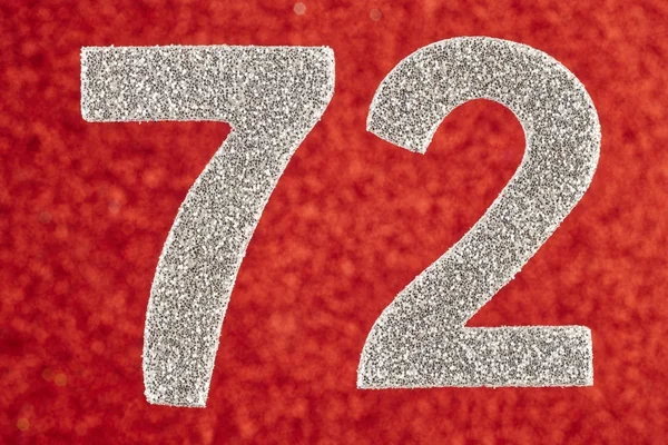 Yetmiş iki gümüş rengi kırmızı bir arka plan üzerinde numara. Anniversa