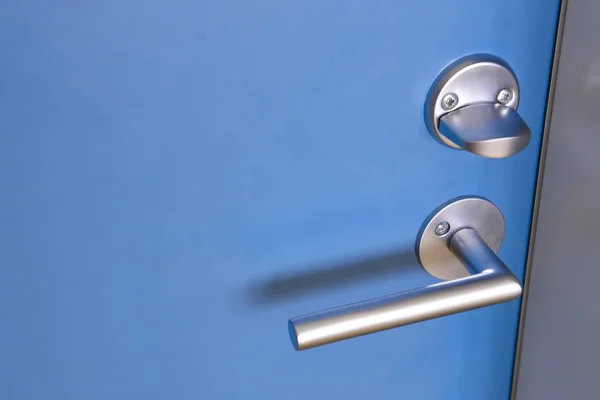 Pomello metallico con serratura su una porta blu . — Foto Stock
