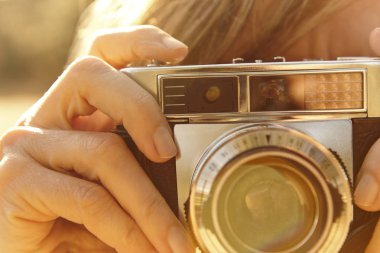 Kadın vintage fotoğraf makinesi ile fotoğraf çekmek. Arka ışık. Seyahat