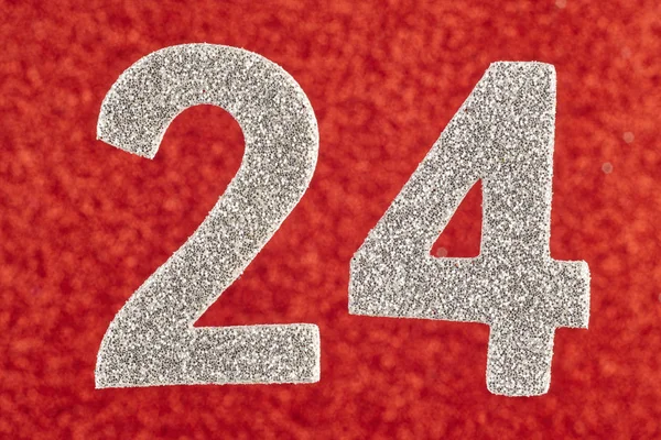 Número vinte e quatro cor de prata sobre um fundo vermelho. Anniversa — Fotografia de Stock
