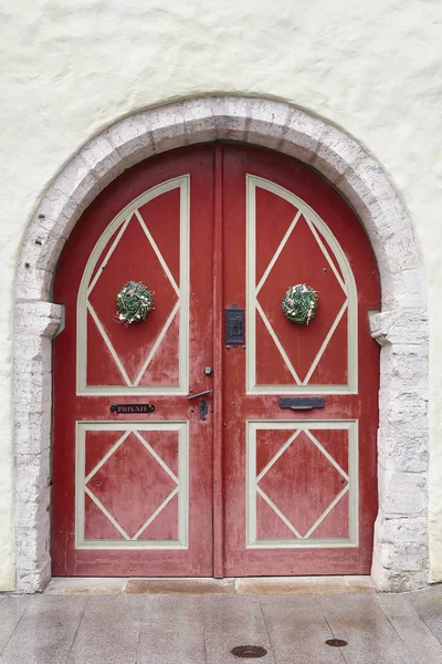 Röda gamla gammaldags trä dörr på vit fasad. Tallinn — Stockfoto