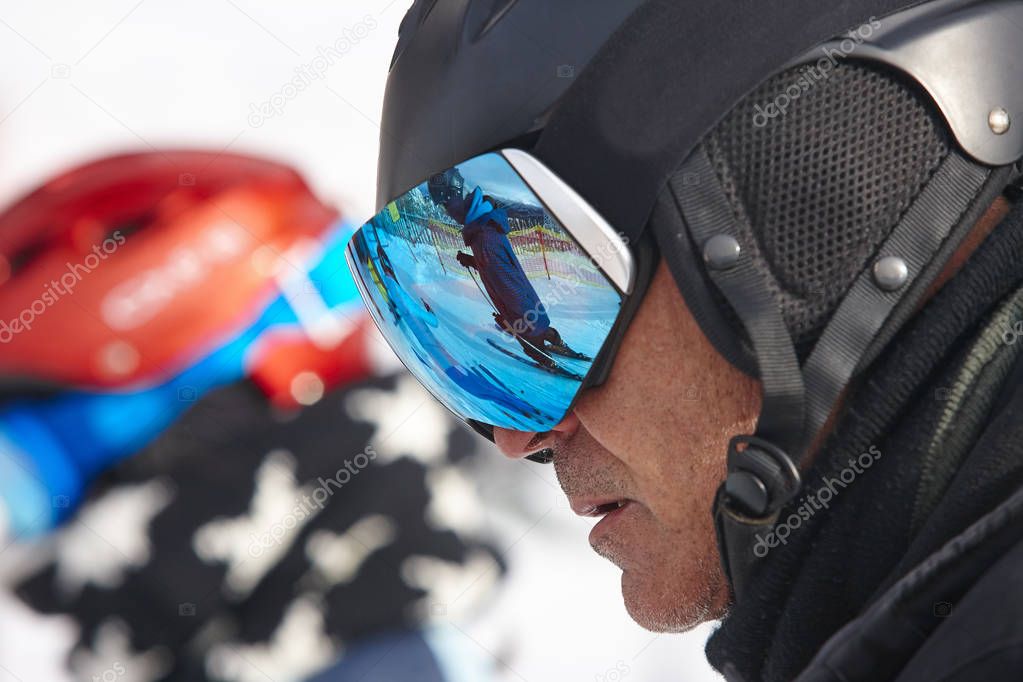 Ski goggles on a white winter landscape. Blue reflection