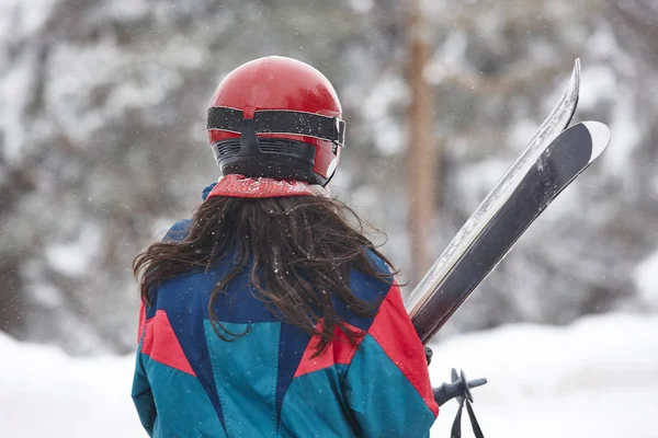 Σκιέρ κρατώντας τα πέδιλα του σκι στη χιονισμένη μέρα. Χειμερινά σπορ — Φωτογραφία Αρχείου