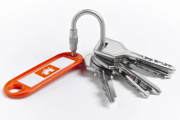 Sleutelhanger met sleutels over witte achtergrond. Huis — Stockfoto
