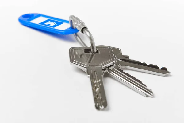 Nyckelring med nycklar över vit bakgrund. Hem — Stockfoto