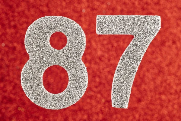 Αριθμός ογδόντα επτά ασημί χρώμα πάνω σε κόκκινο φόντο. Annivers — Φωτογραφία Αρχείου