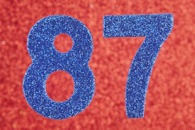 87 mavi renk kırmızı bir arka plan üzerinde numara. Anniversar