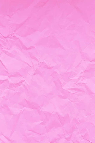 Pink crumpled wrinkled textured paper background.