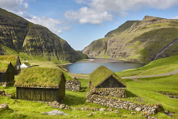 Malebná zelená krajina s černými domy na Faerských ostrovech. — Stock fotografie