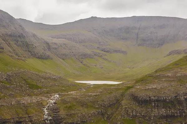 Faroe island cloudy landscape with valley lake and rocky mountai — Stock Photo, Image