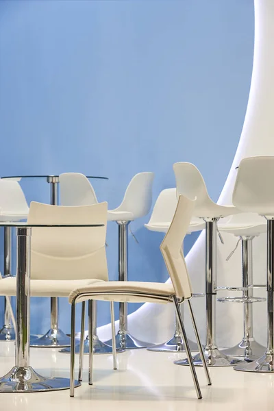 White chairs and tables in a blue room. Decoration — Stock Photo, Image