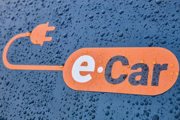 Ηλεκτρικό λογότυπο αυτοκινήτου σε ένα σώμα αυτοκινήτου. Ανανεώσιμες πηγές — Φωτογραφία Αρχείου