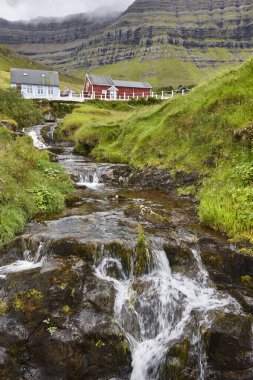 Geleneksel Faroe köyü Kunoy nehri ve dağ manzaralı.