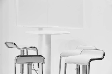 Şık sandalyeleri ve masaları olan kapalı alan beyaz seti. En küçük dekorasyon