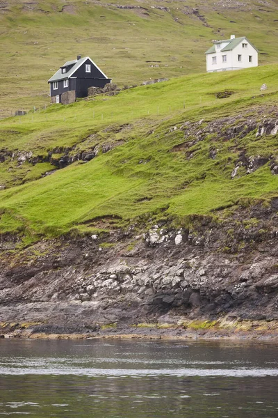 岩石海岸线上 有着传统的风景如画的房子的法罗式绿色风景 — 图库照片