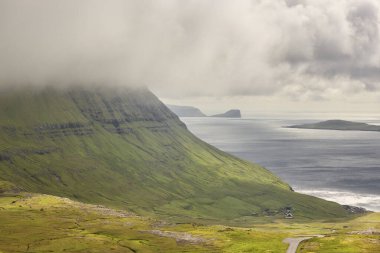 Faroe adalarındaki yeşil çim tepeleri ve fiyortlar. 