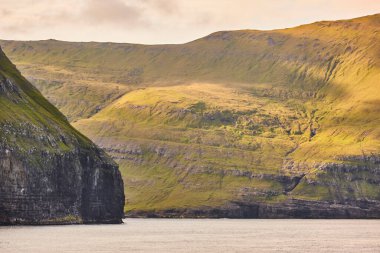 Faroe adalarındaki yeşil dağ kayalıkları manzarası. Sudoroy uçurumları