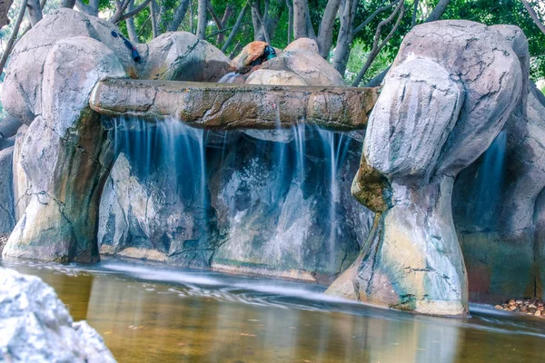 Waterfall in the park. Artificial waterfall in the garden. Blurred motion.