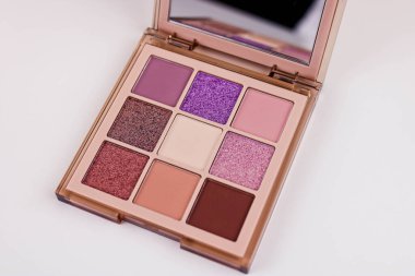 Beyaz bir kozmetik masasında izole edilmiş dokuz renk far seti. Renkli göz farı renkleri.