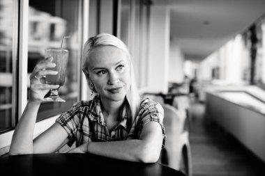 Yaz tatili kadını, tropik bir tatil köyünde havuz kenarında alkolsüz içki içiyor..