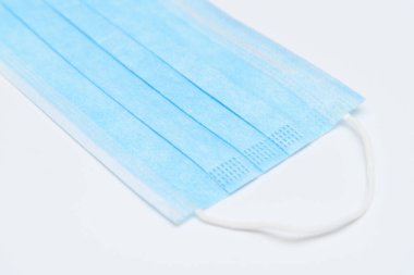 Grip ve diğer hastalıklara karşı korunmak için mavi tek kullanımlık yüz maskesi. Beyaz arka planda cerrahi maske. 